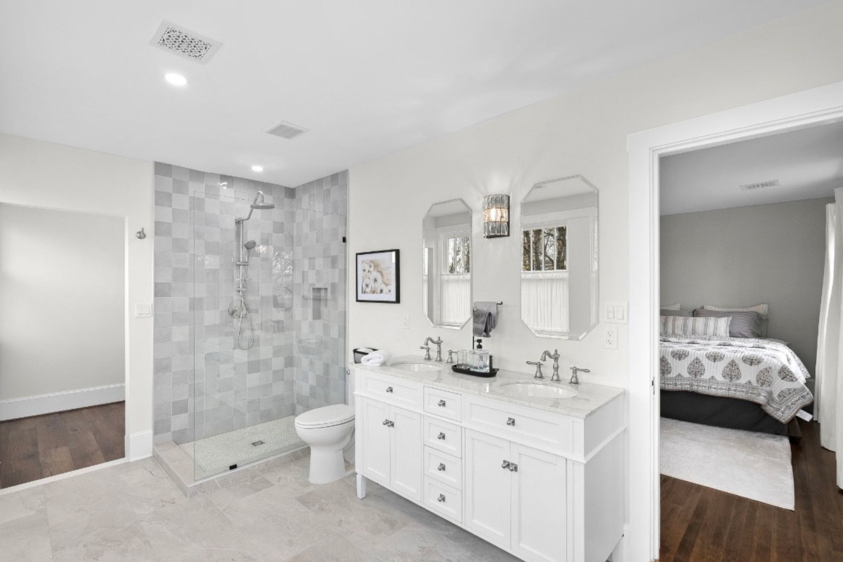 bathroom with walk-in shower and his and hers vanity