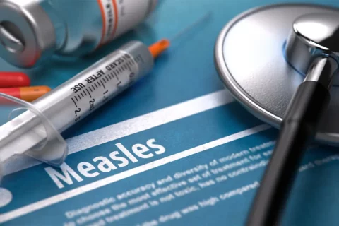 measles with a stethoscope and vaccine needle and vile