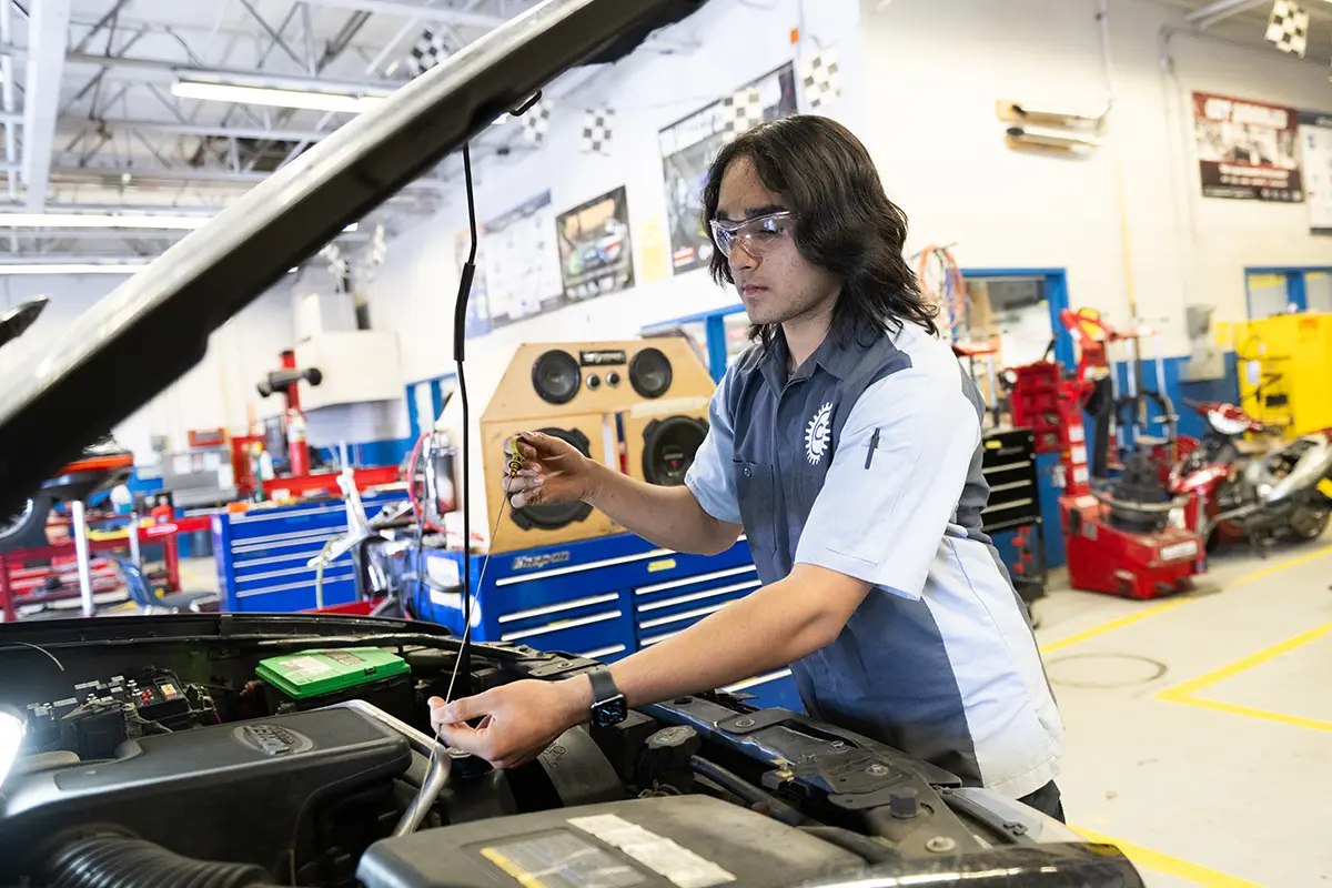 Chantilly Academy student Om Desai looks under the hood of a car