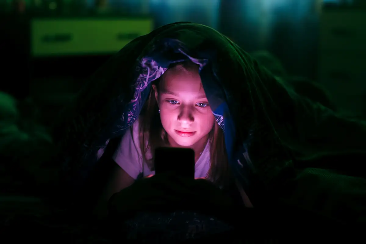 Girl looking at phone at night