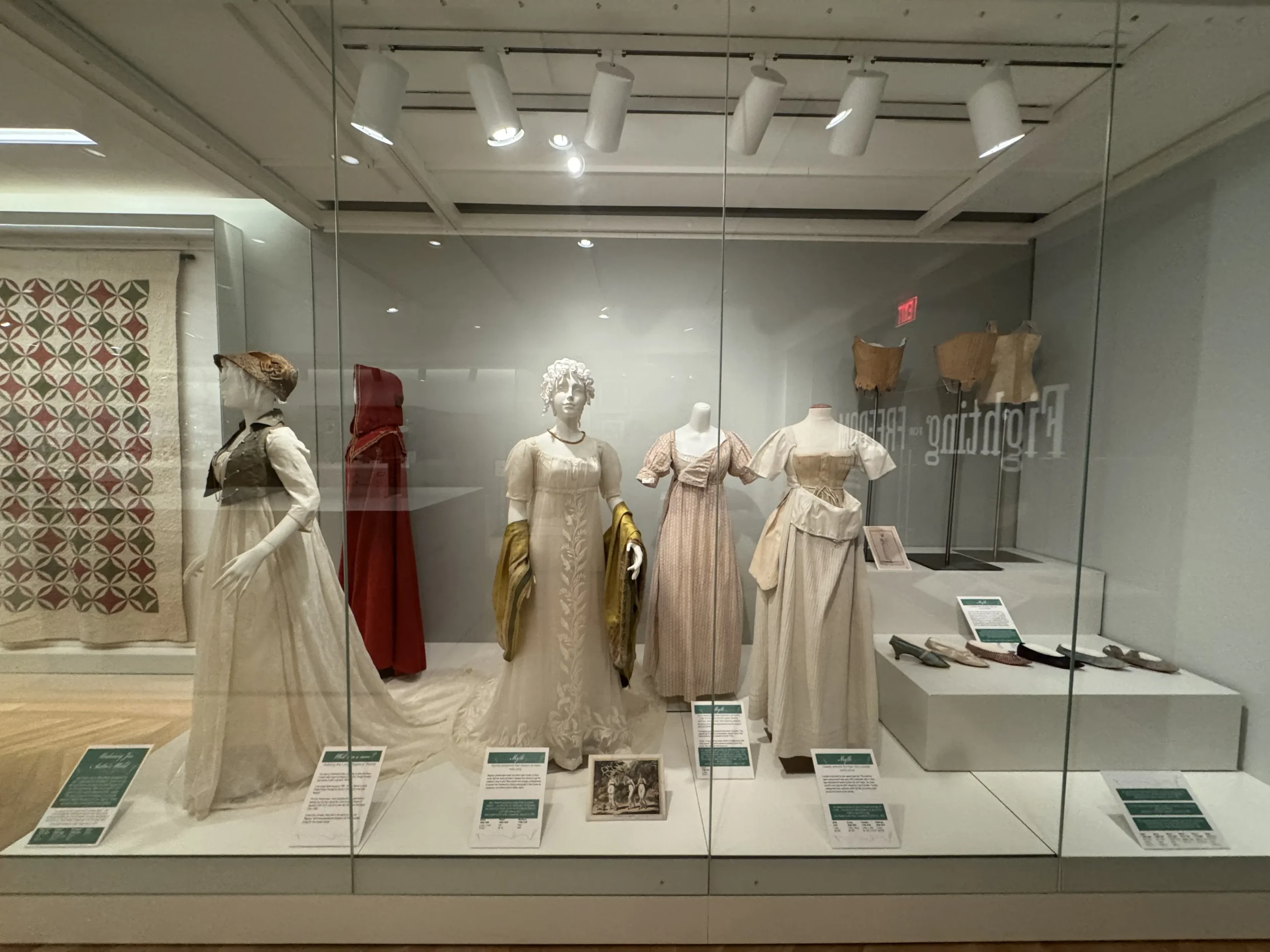 dresses behind a display case at the Undressing Jane Austen’s World exhibit