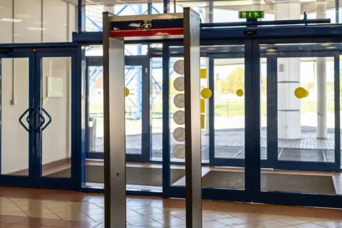 metal detectors in the lobby of a building in front of glass doors