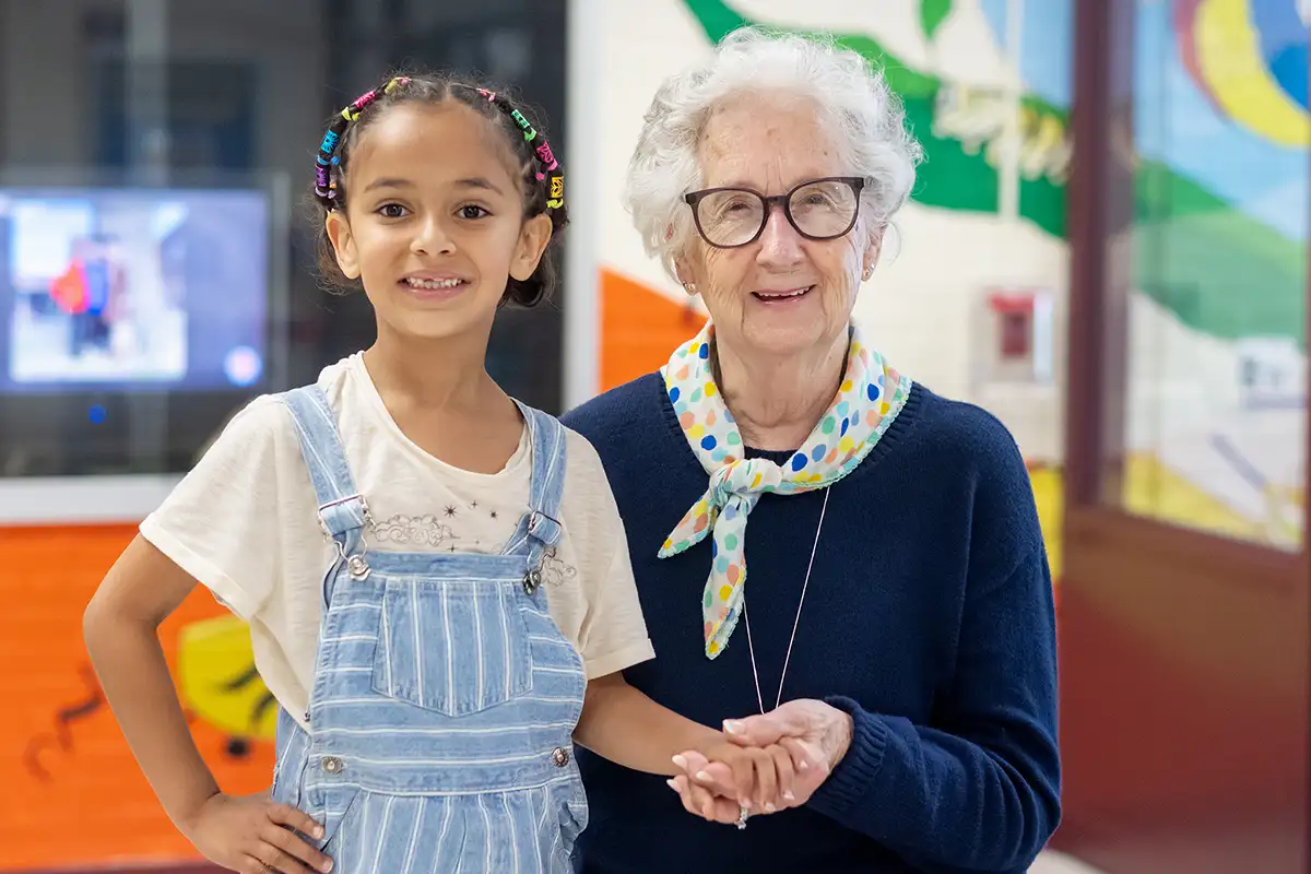 Joyce Sisk standing with her granddaughter