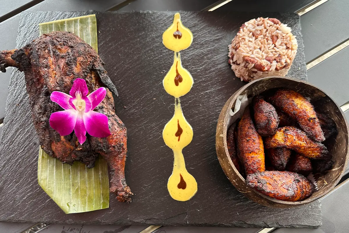 a dish of chicken, rice, and plantains at Xaymaca