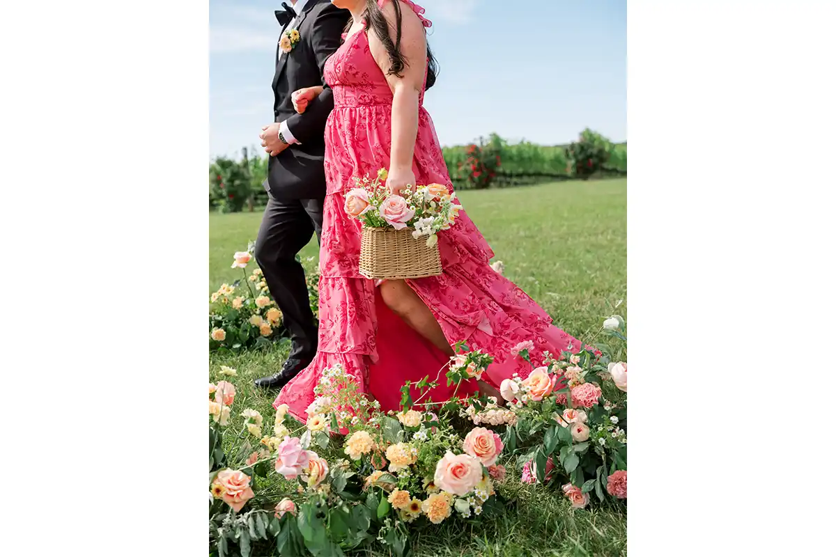 bridesmaid wearing pink gown carrying basket of flowers