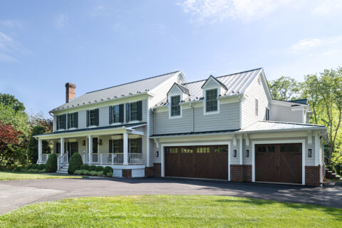 grey farmhouse with brown garage doors