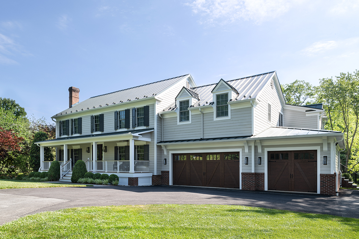 grey farmhouse with brown garage doors
