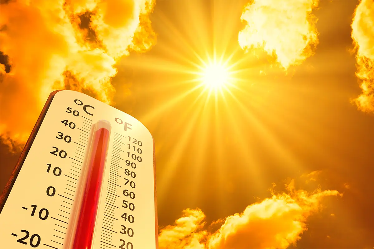 a thermometer registering over 100 degrees with the sun and sky in the background