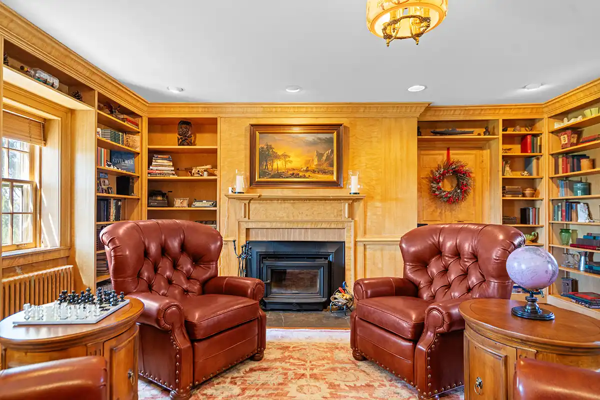 home library with leather chairs in front of fireplace 