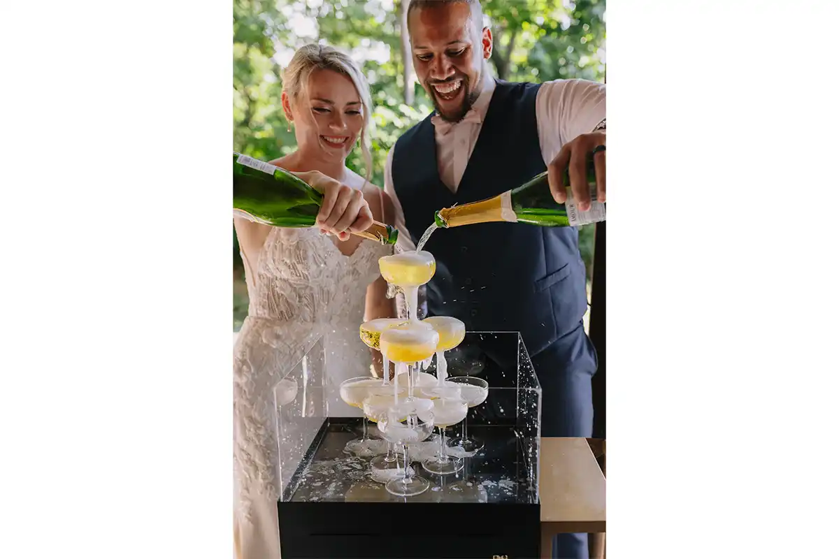 couple pouring champagne down champagne tower