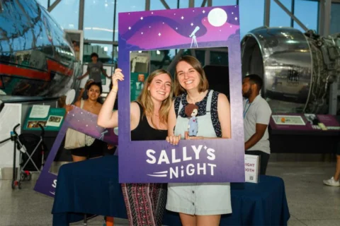 Two women holding cardboard for Sally's Night