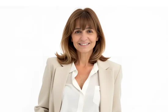 Real Estate agent Maryanne Moyers in a tan suit on a white background