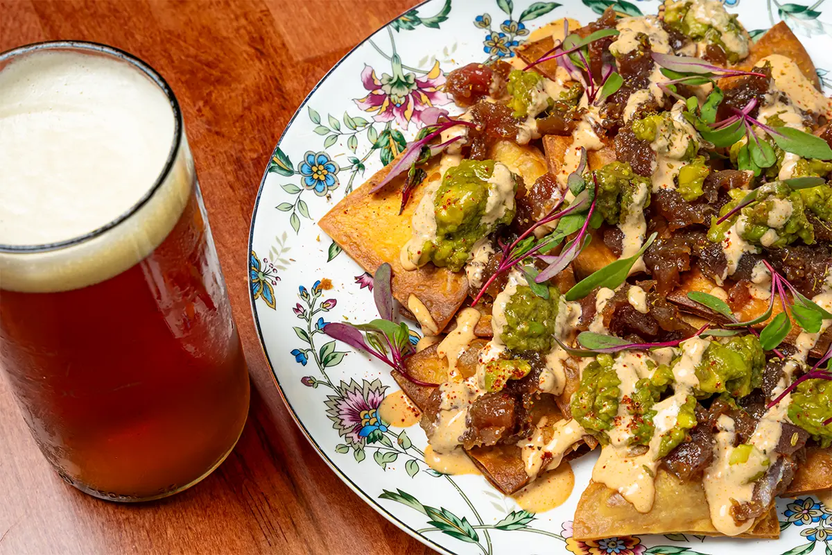 Tuna Poke Nachos and a beer on a table at Harvey's