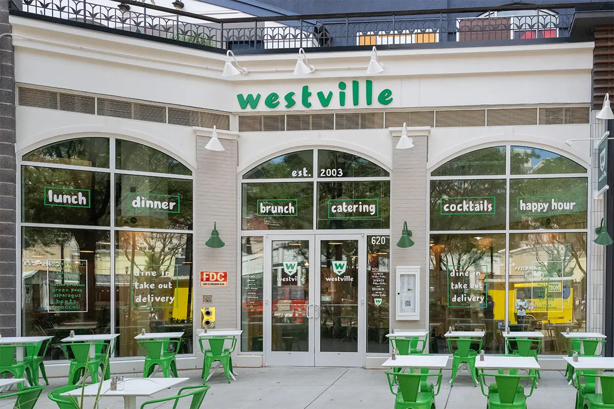 exterior view of Westville in Clarendon with green tables and chairs with white tops