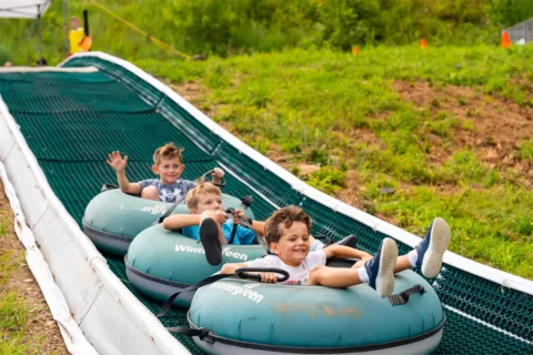 three young boys in tubes on The Plunge track at Wintergreen Resort