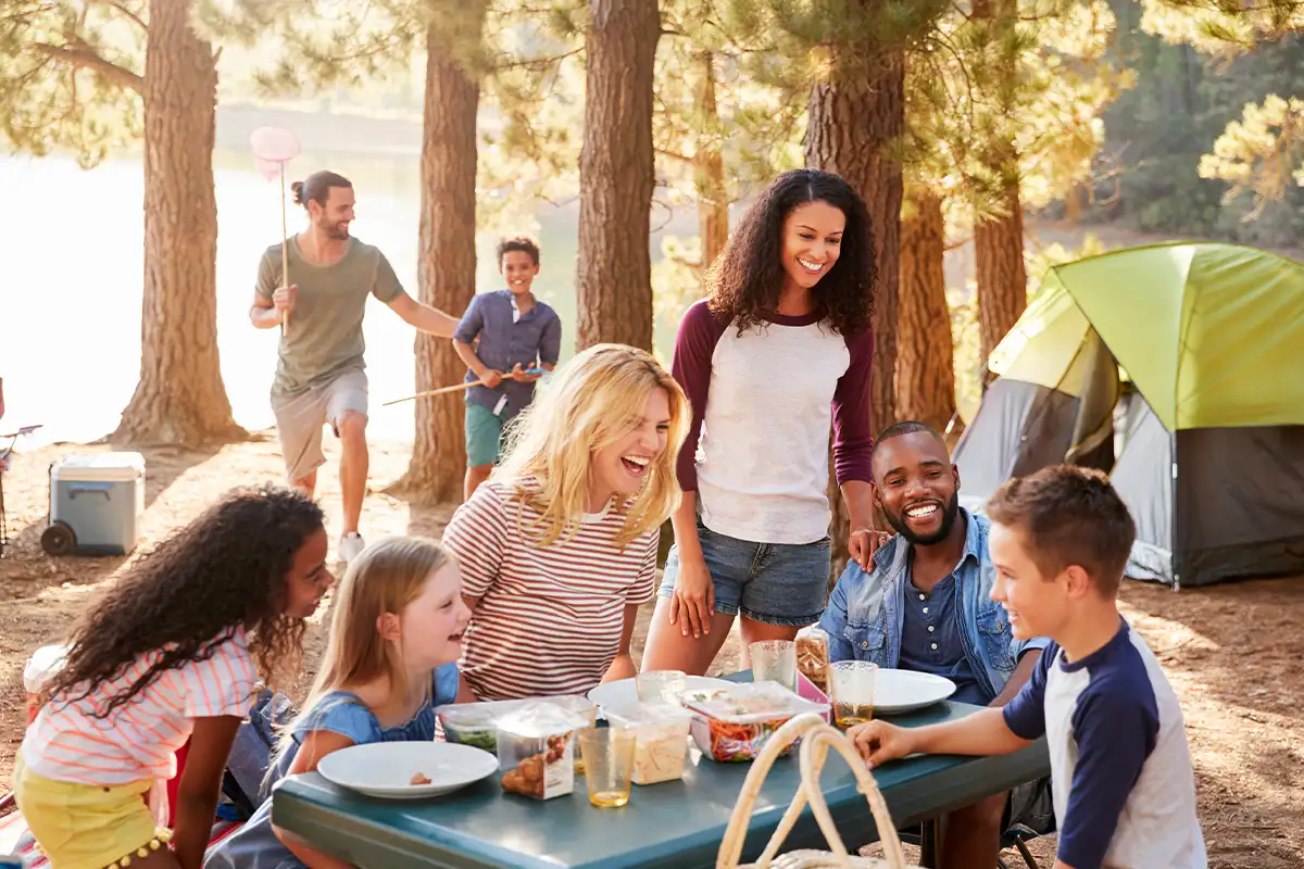 families at a picnic table at a campground