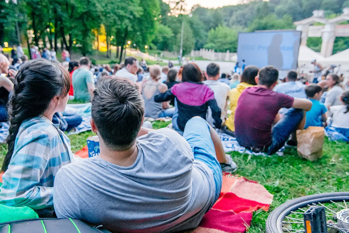 people sit on the grass watching an outdoor movie