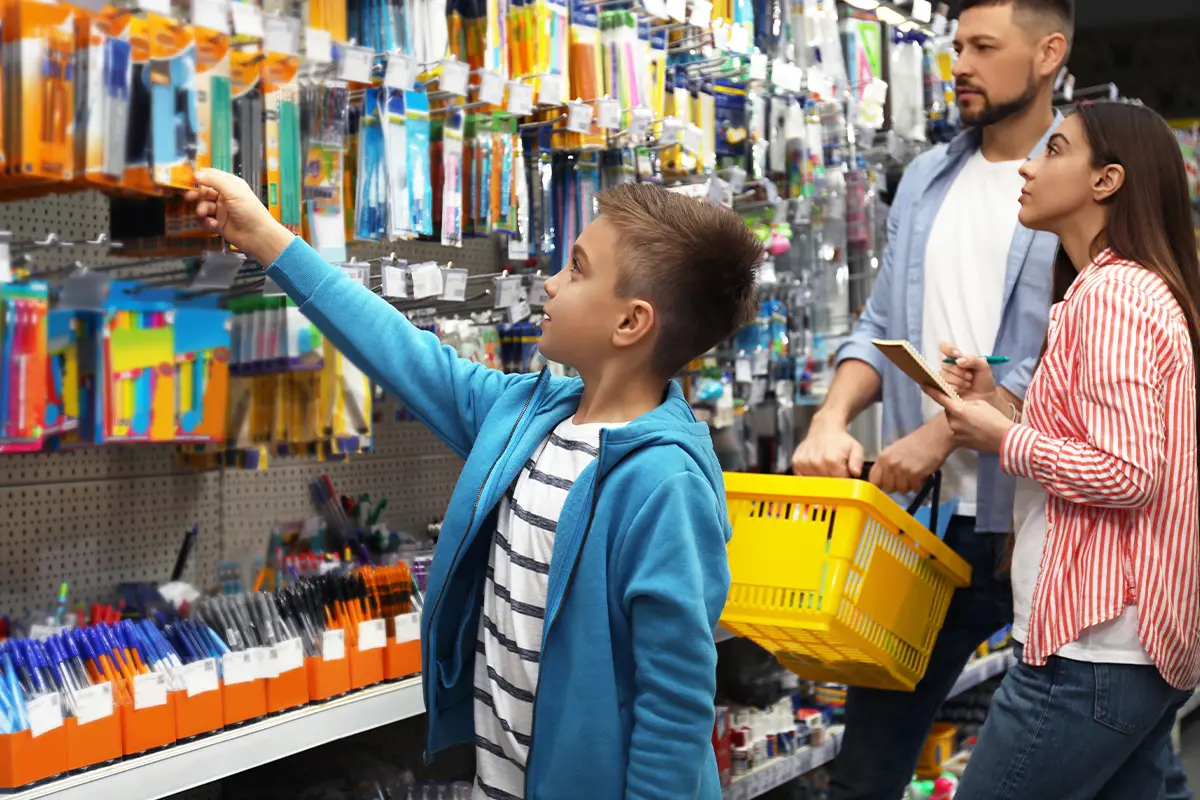 a child and his parents shopping for school supplies
