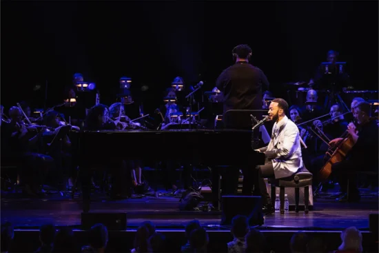 John Legend on stage playing piano and singing at Wolf Trap