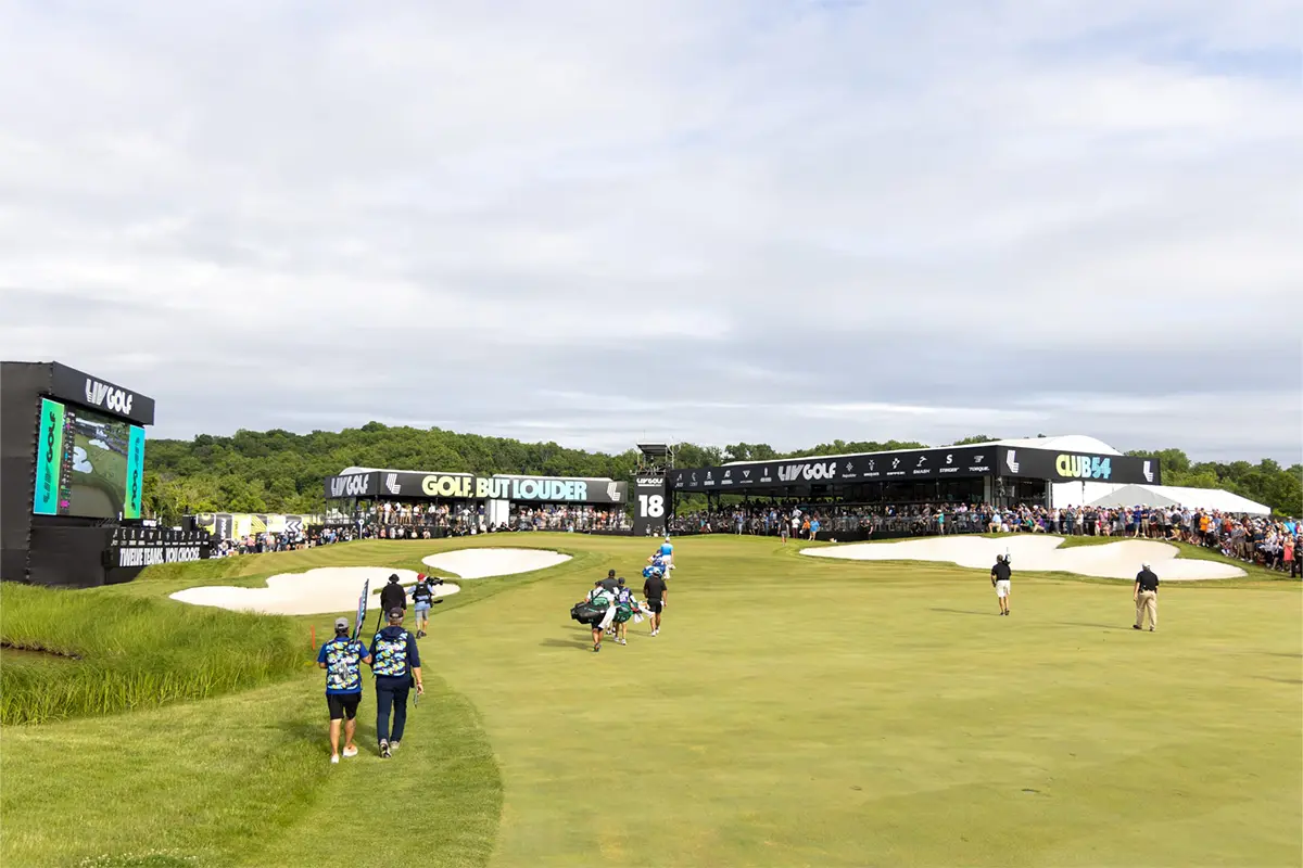 golfers and caddies walk a course at a LIV Golf tournament