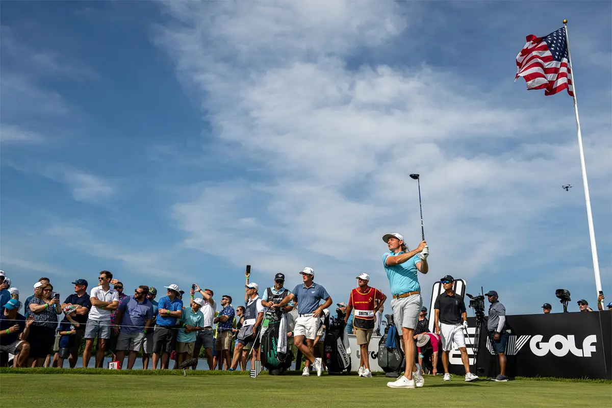 Spectators watch a golfer take a shot at a LIV tournament