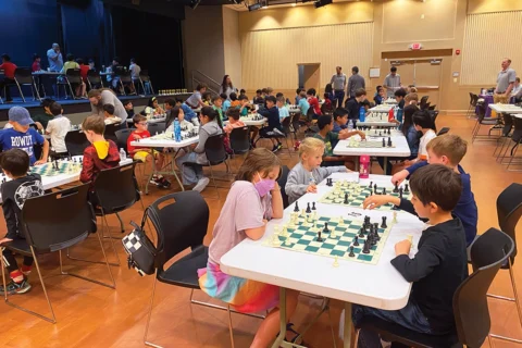 room full of children playing chess