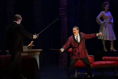 a guy fighting off with a sword in The Addams Family