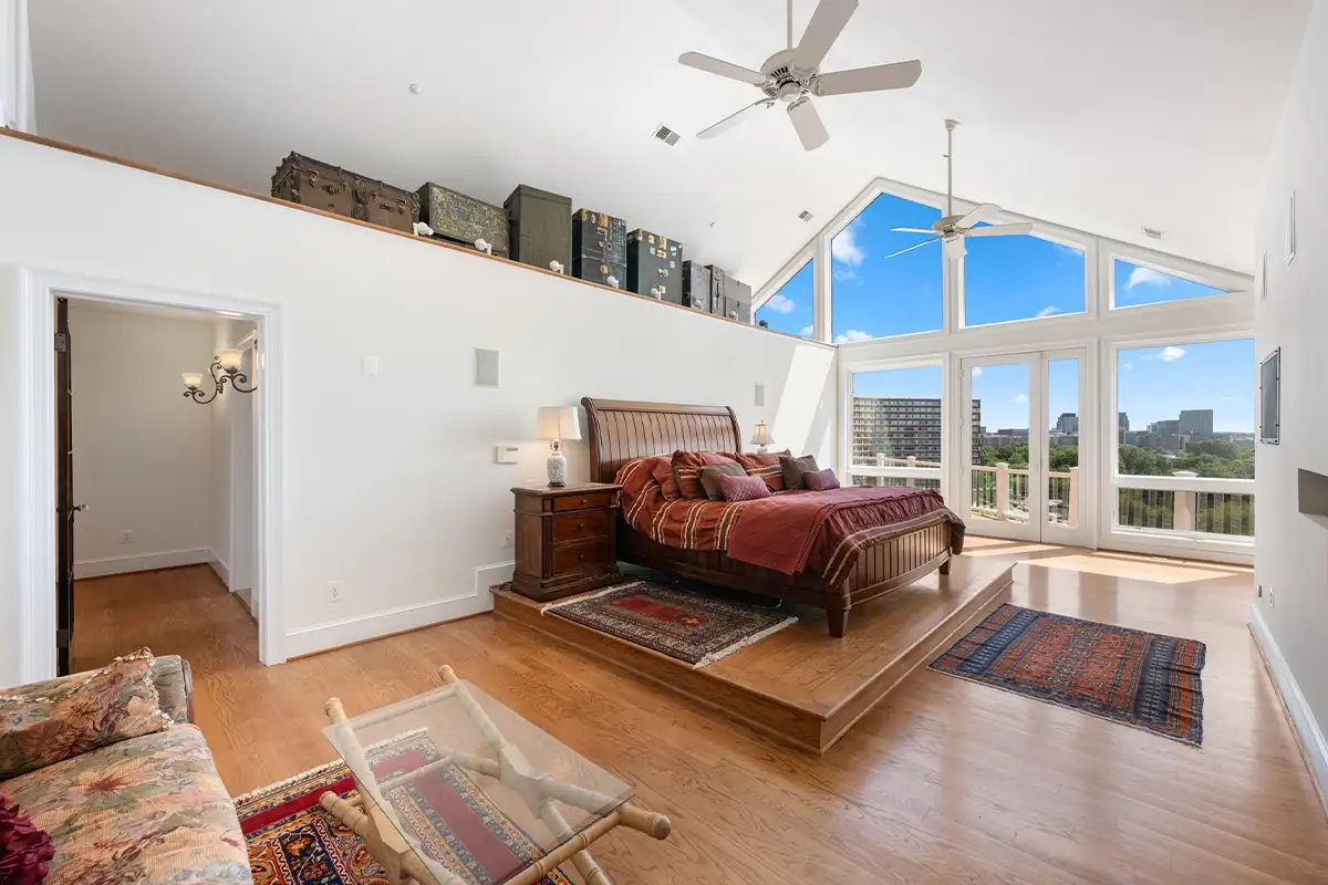 Primary bedroom with vaulted ceilings and windows
