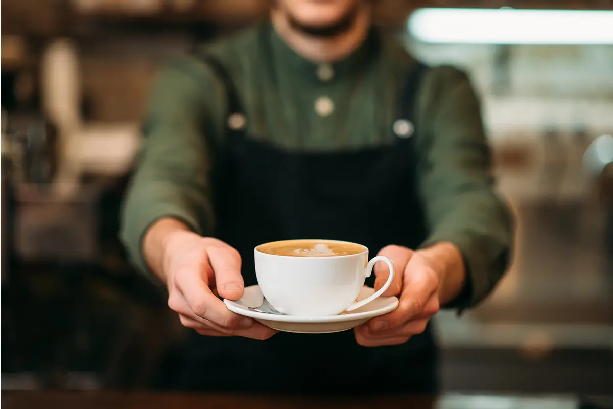 a server handing a cup of coffee