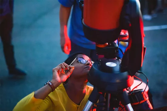 a child with a telescope at Smithsonian’s National Air and Space Museum