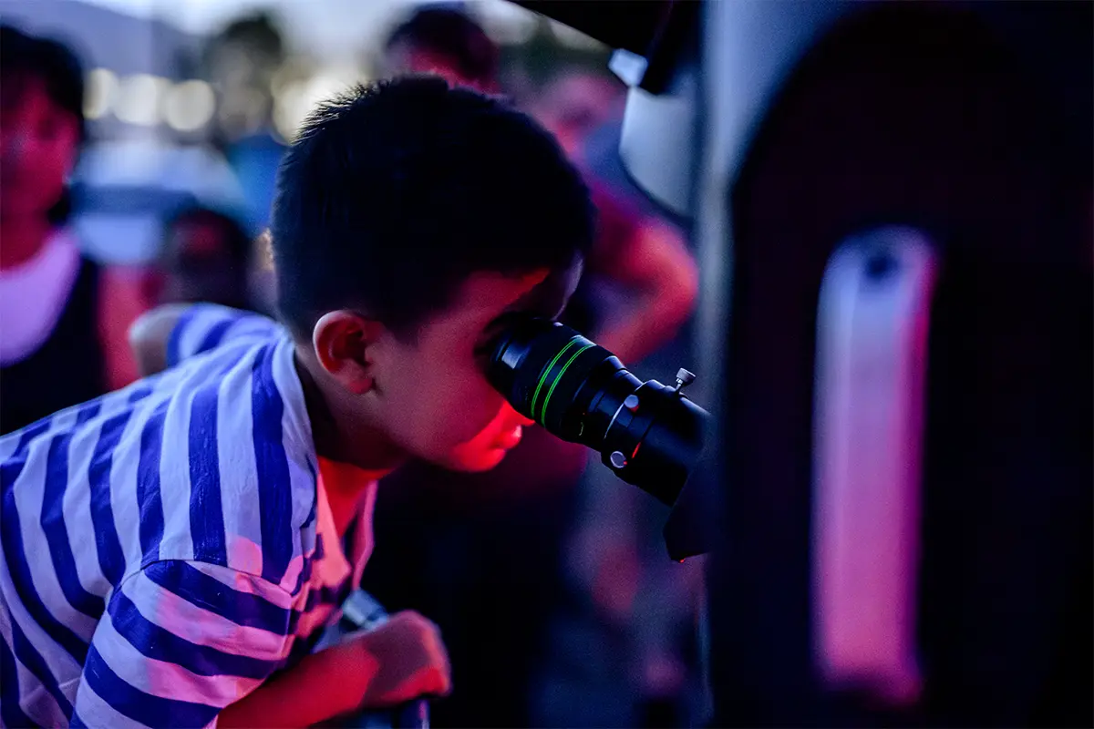 a child looks into a telescope at aSmithsonian National Air and Space Museum stargazing event