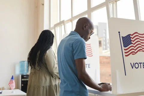 the backs of two people as they vote