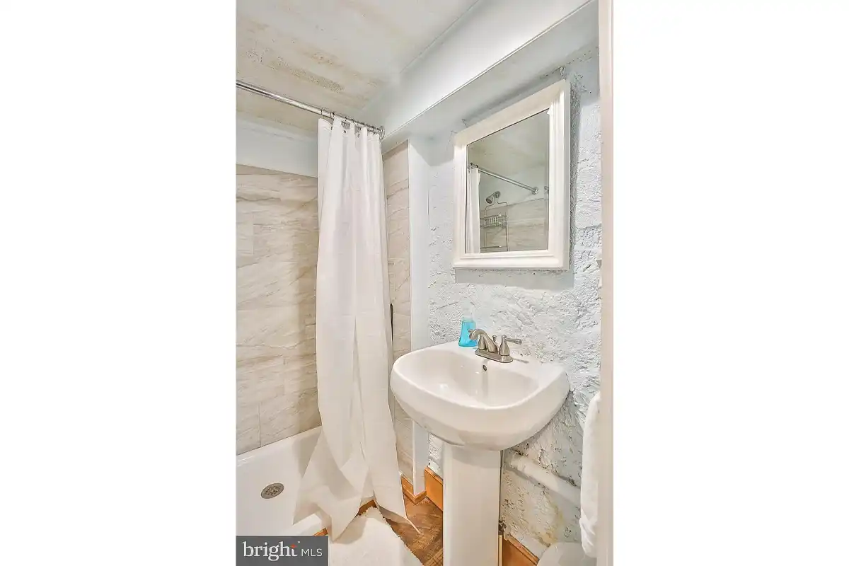 bathroom with stone walls and walk-in shower