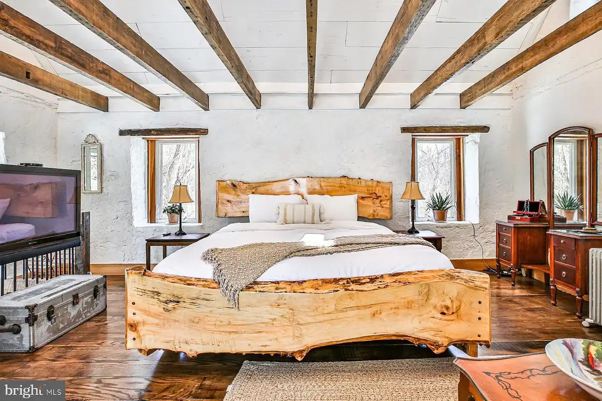 bedroom with wood beams and hardwood floors