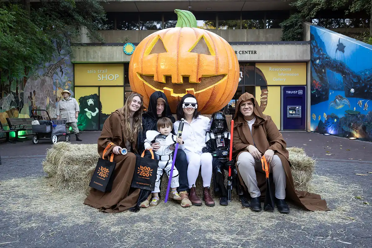 family wearing star wars costumes in front of giant pumpkin