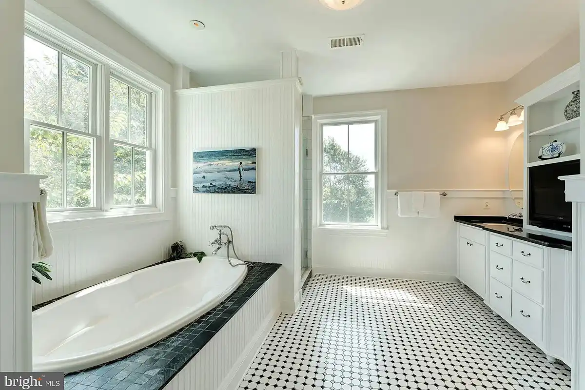 bathroom with tub and black and white flooring