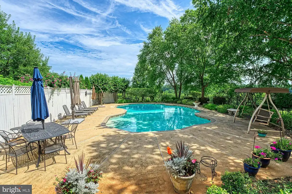 in-ground pool with patio furniture