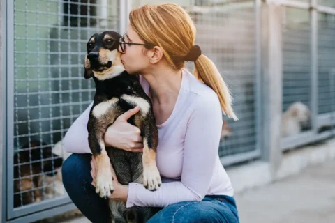 Woman kissing dog at animal shelter