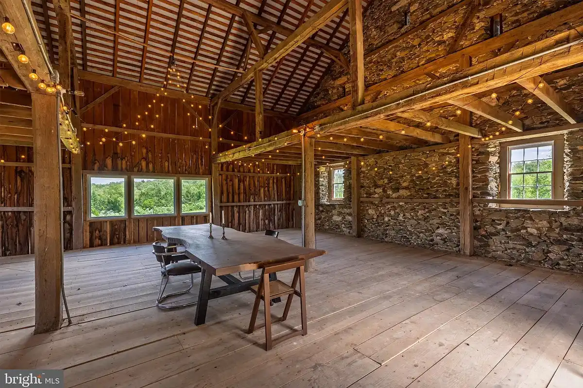 inside of barn with string lights hanging from rafters