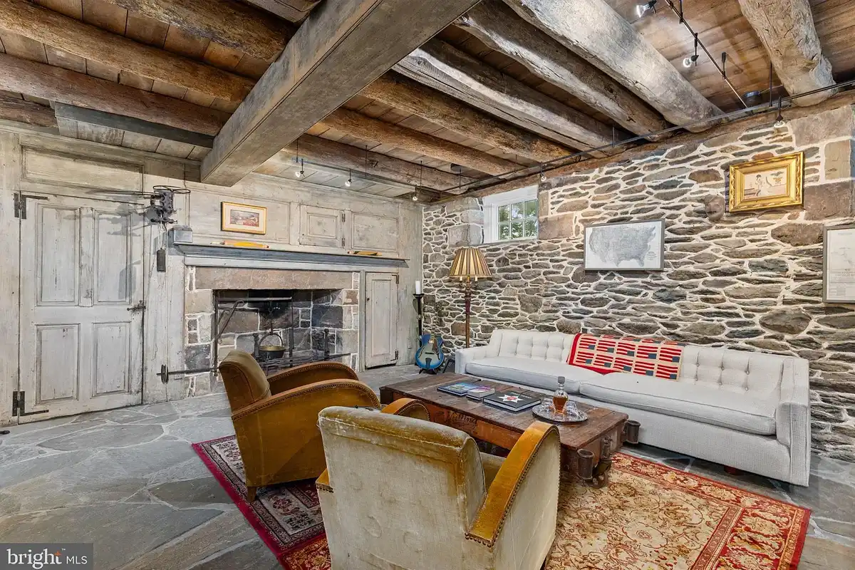 lower level with stone walls and wood beam ceiling