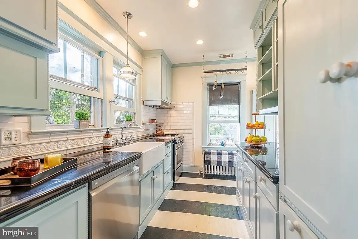 The galley kitchen with custom cabinets and striped flooring at 222 Locust St.