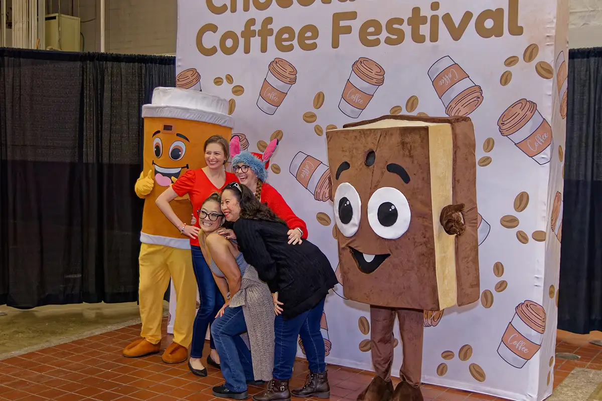 group posing with chocolate and coffee mascot