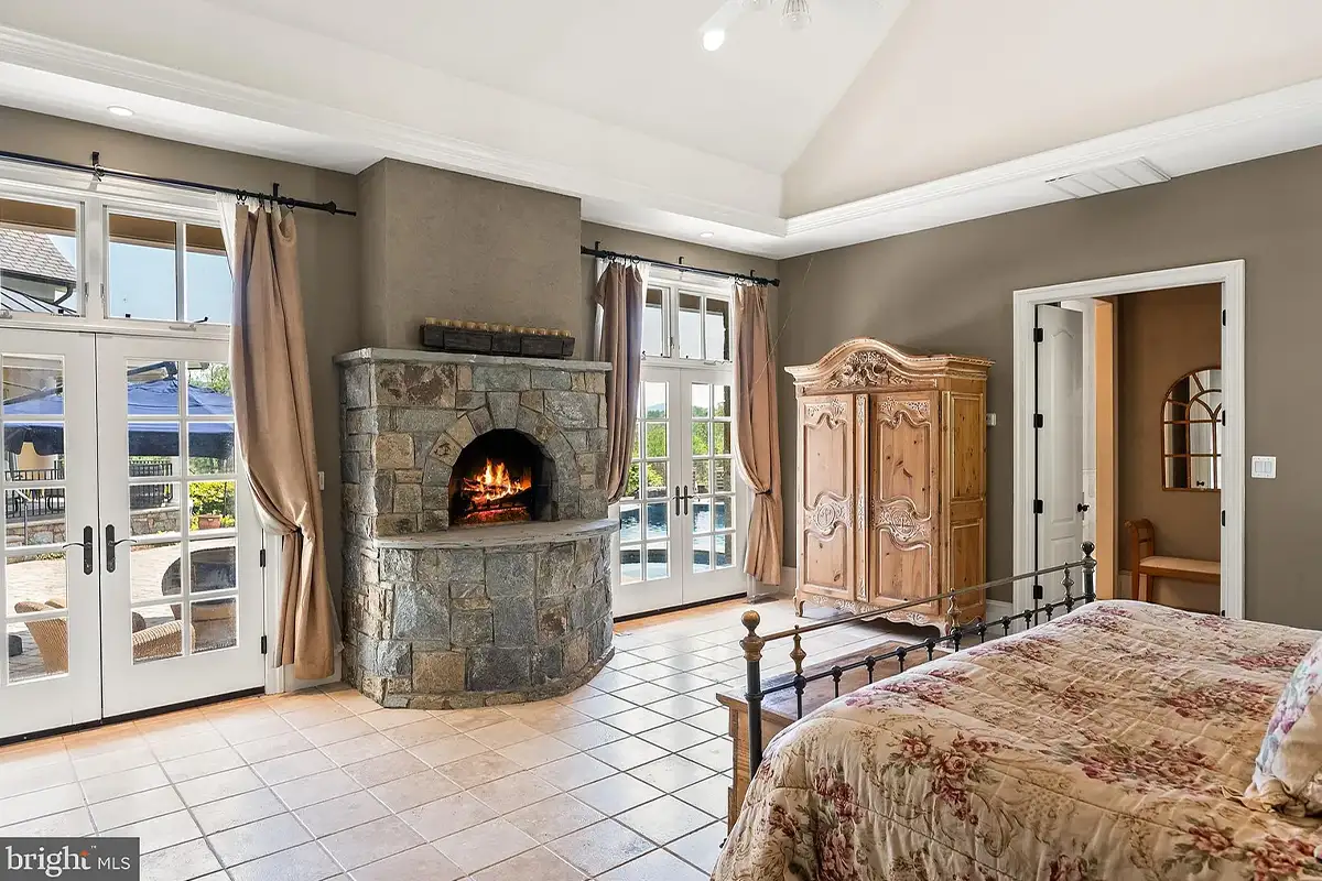 Bedroom with stone fireplace and french doors