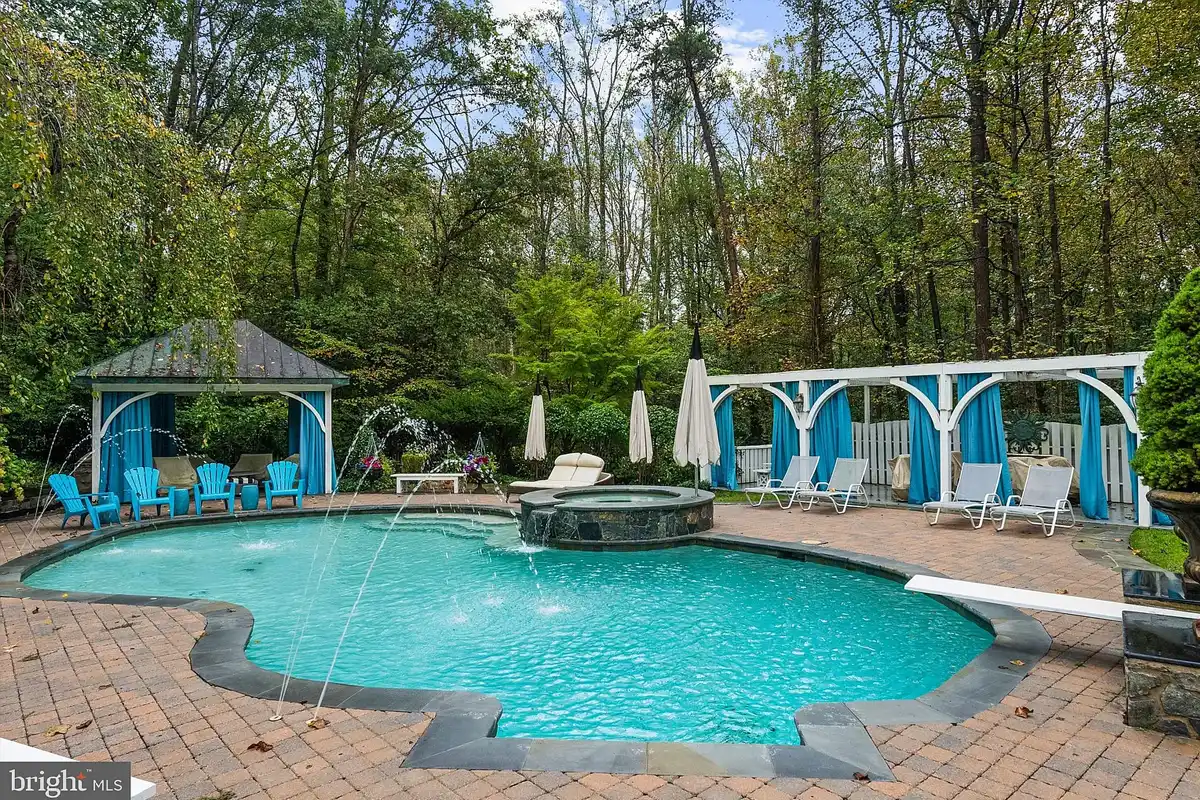 in-ground pool with diving board and spa
