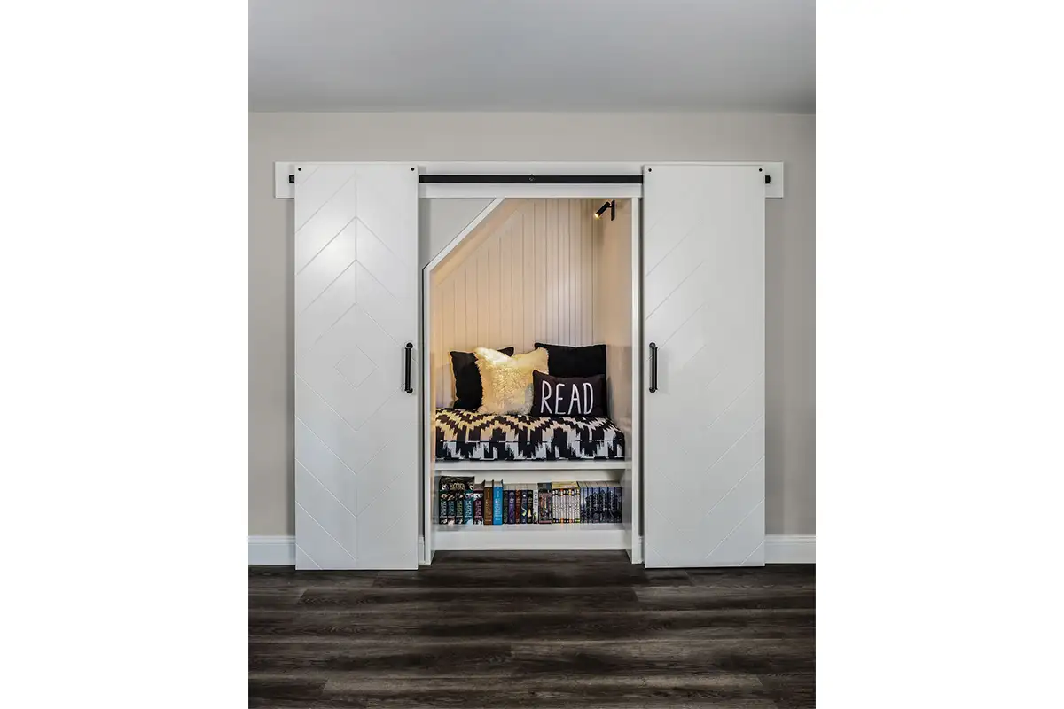 A reading nook with a built-in shelf and barn doors