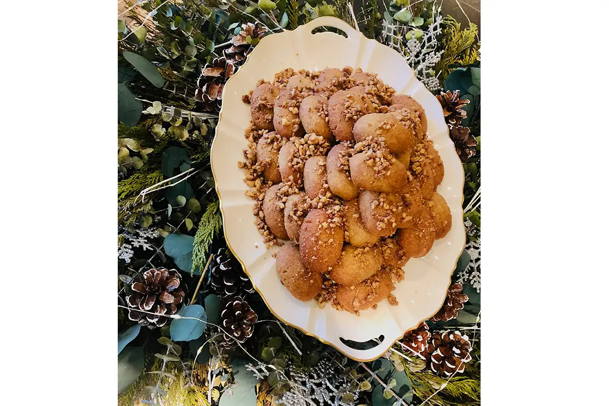 a plate of food at Nostos with holly and pinecone decorations on the table