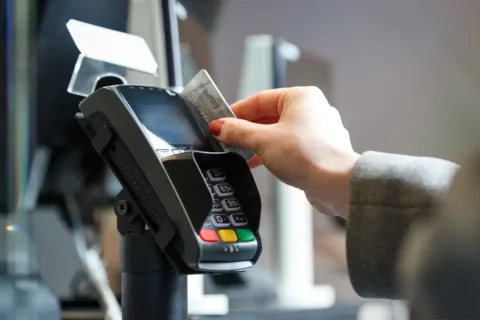 a person swipes a credit card as payment in a machine