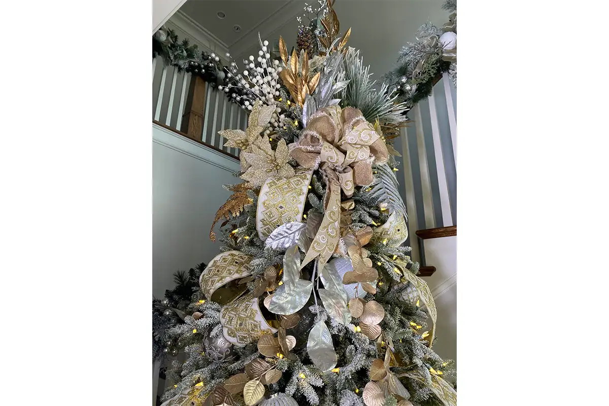 the top of a Christmas tree decorated with ribbon