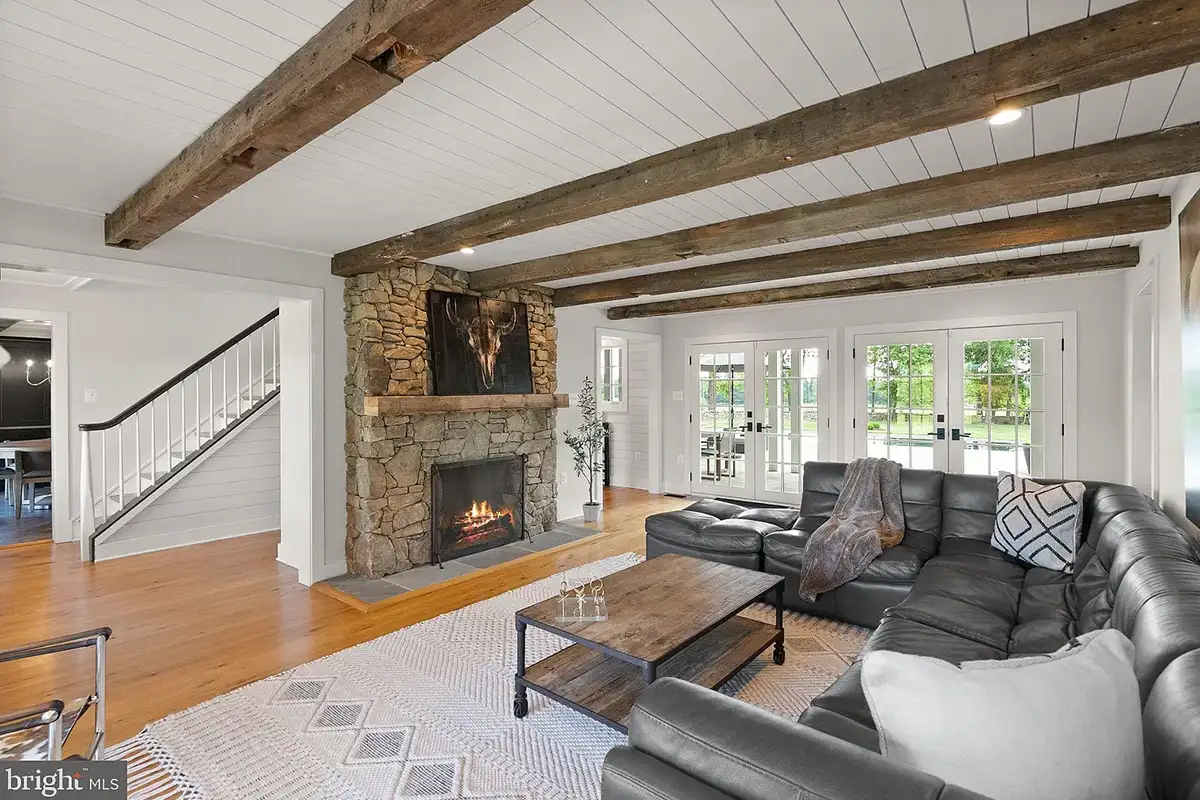 Living room with fireplace, shiplap ceiling, wood beams