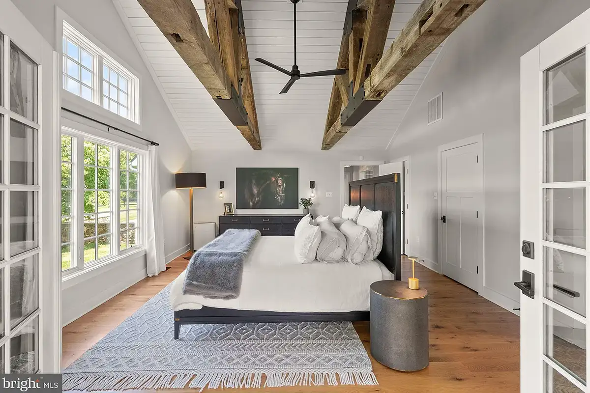primary bedroom with wood-beam ceilings